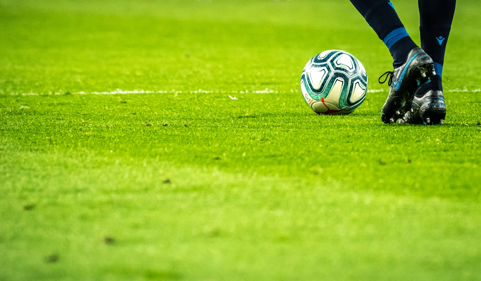 Weiße Linie und Ball auf Naturrasen, Nahaufnahme
